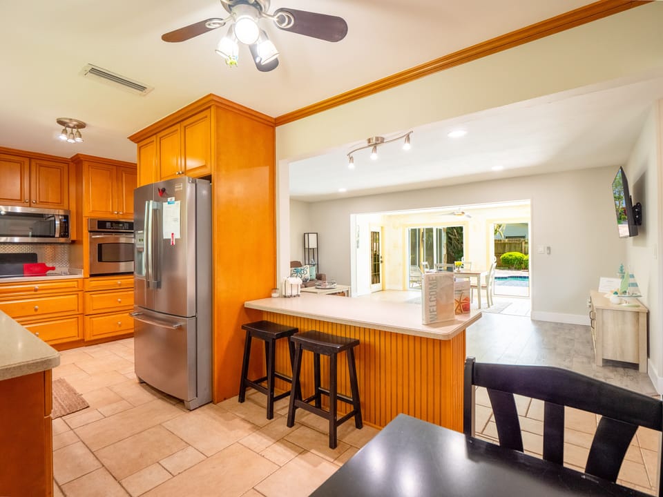 Kitchen, overlooking the living room, sliders leading out to the pool