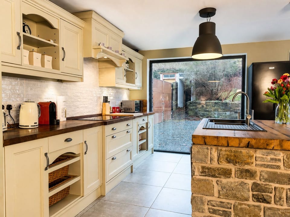 Charming country-style kitchen with stone island and garden views