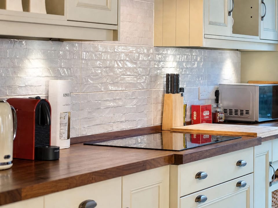 Bright, stylish kitchen with coffee machine, hob, and wood countertops