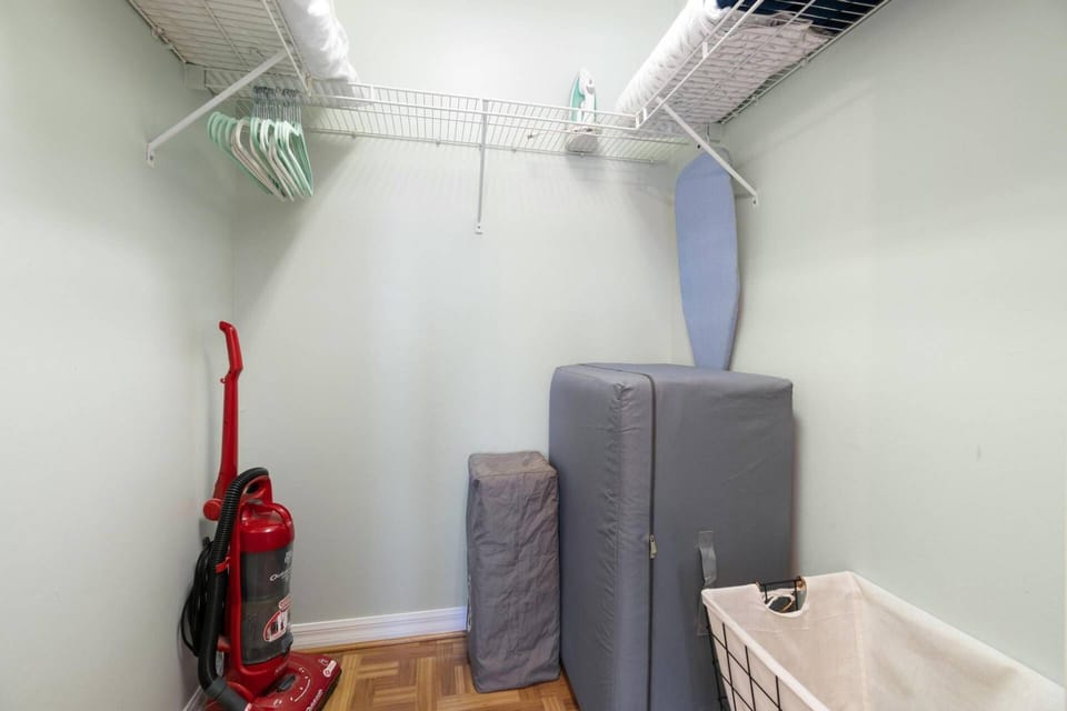 The large primary walk-in closet has lots of hanging space with hangers, an twin fold-out memory foam mattress and an iron and ironing board.