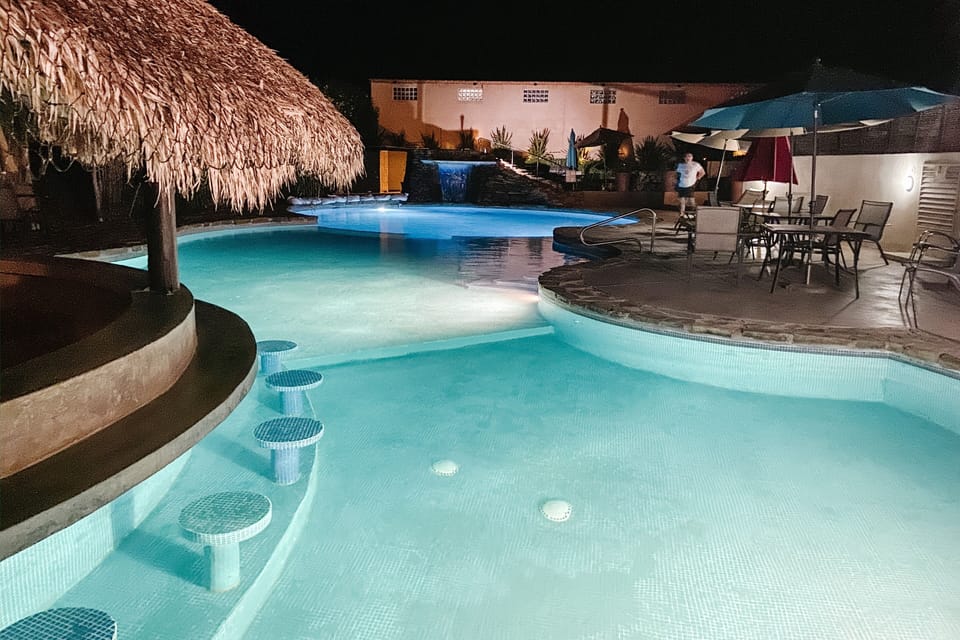 Outdoor pool and hot tub at night 