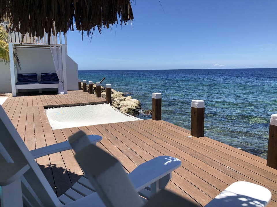 Deck above the ocean, with hammock, daybed and seating.