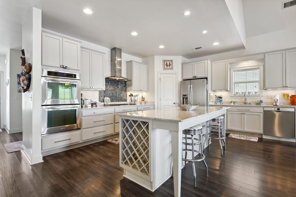 Fully stocked kitchen with gas stovetop and two ovens.
