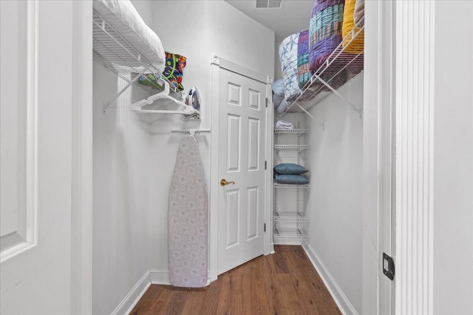 Walk in closet with extra bedding and pillows.