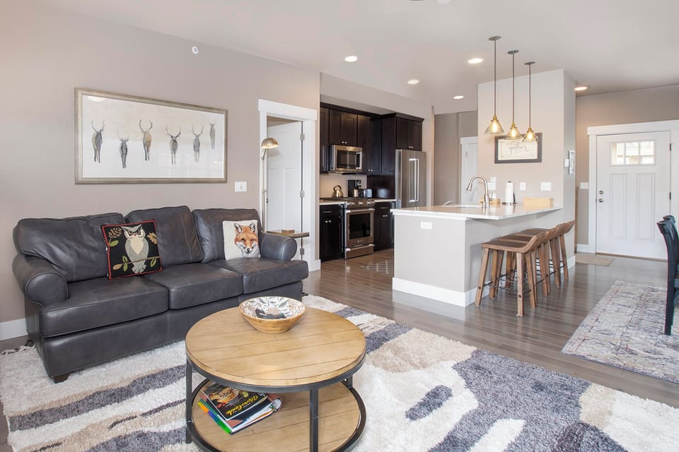 Sink into your cozy leather sofa while enjoying the open-concept design that seamlessly connects your living space to the modern kitchen.