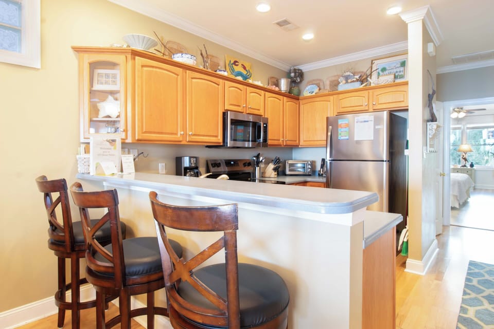 Your fully equipped kitchen features warm wood cabinets, stainless steel appliances, and a breakfast bar where you can start each day.