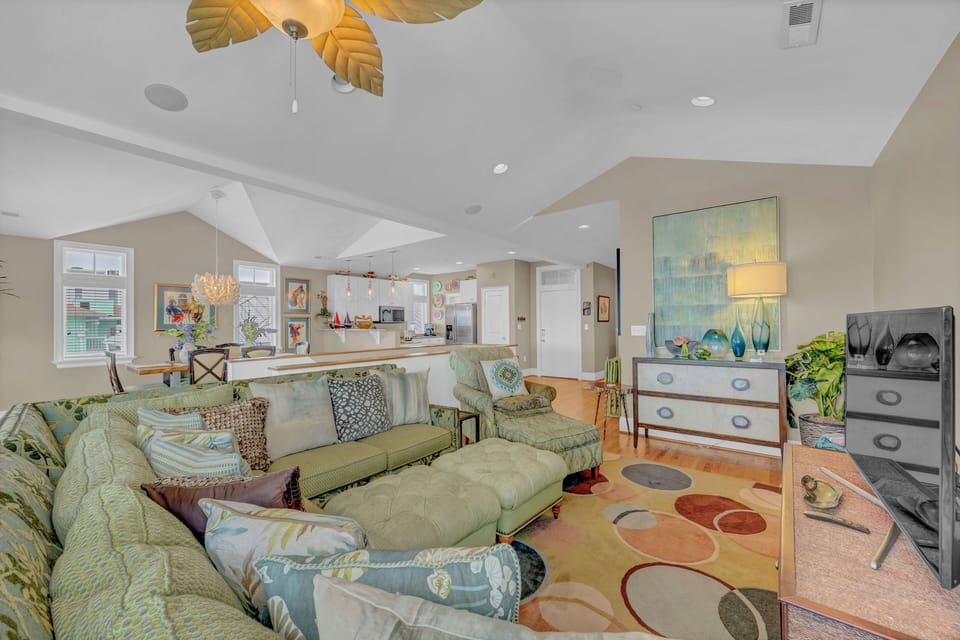 Sink into plush seating and unwind in your spacious living area, where coastal colors, unique ceiling accents, and an open-concept design create a bright, welcoming retreat for your stay.