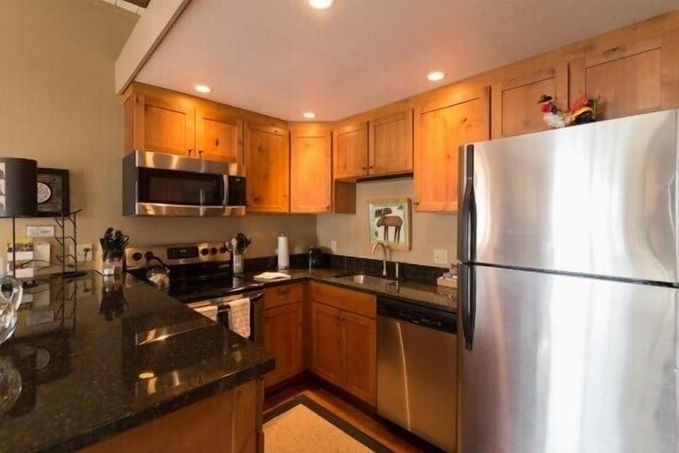 Your fully equipped kitchen features granite counters, stainless steel appliances, and warm wood cabinets for all your culinary adventures.