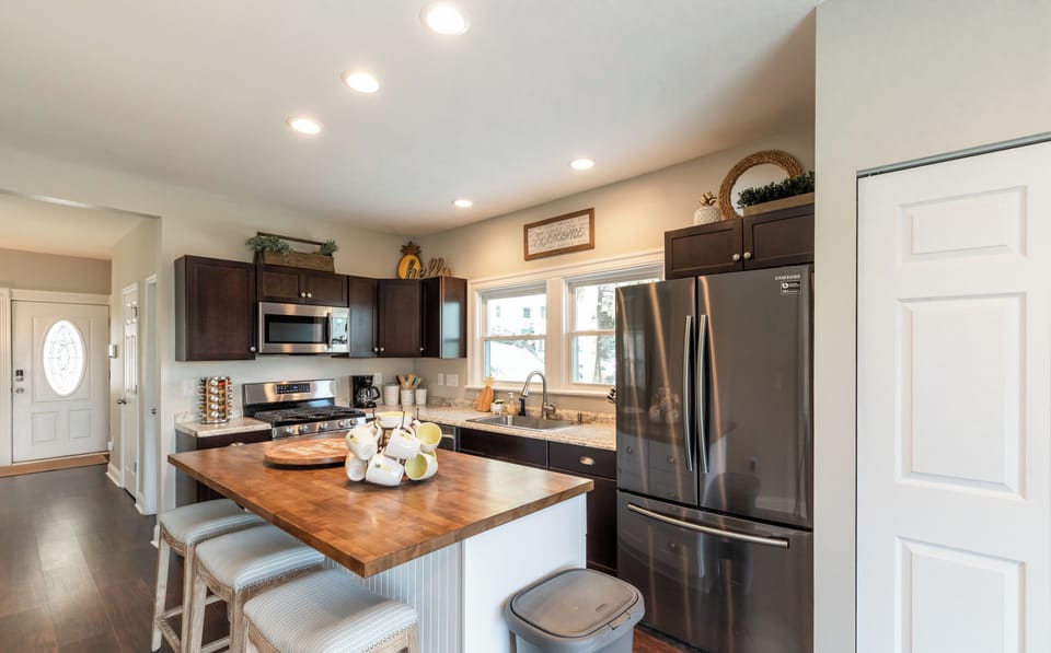 Large open kitchen with island and new stainless steel appliances.
