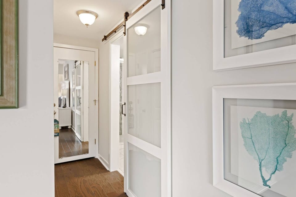 Barn door leading to en suite bath in primary bedroom
