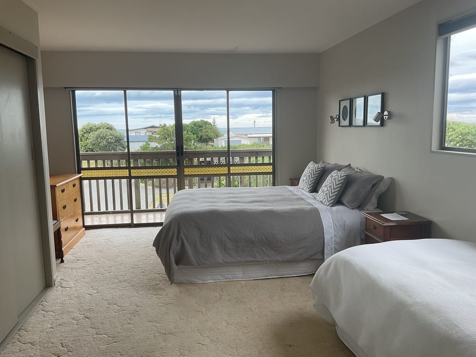 Large sunny queen room with extra single bed, view and access to deck