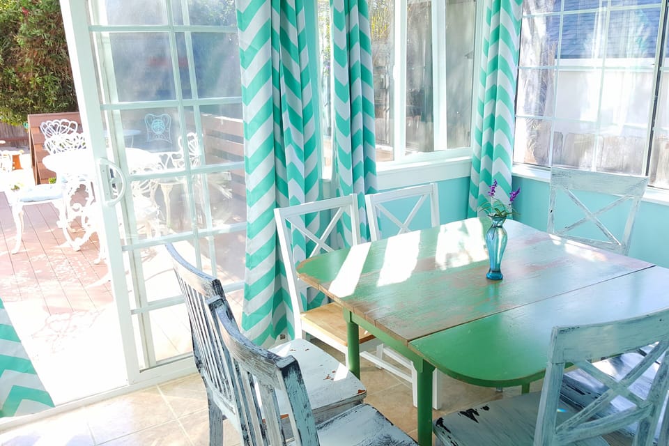 Sunny dining room seats eight and leads to deck. Dig that antique table!