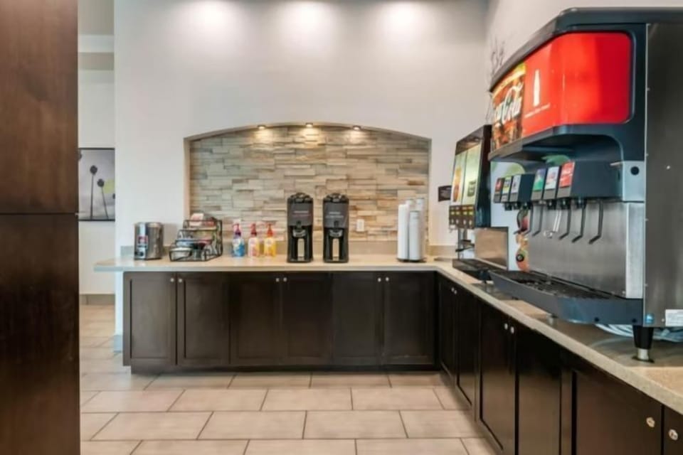 Beverage station with soda fountain, coffee machine, and stone arch wall feature