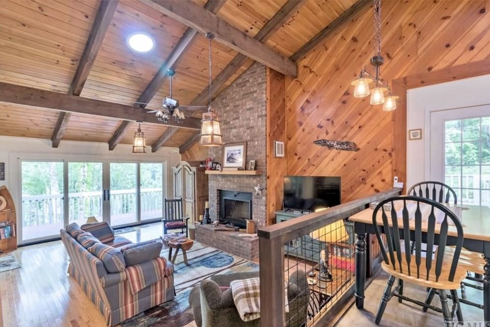 Living Rm with wood burning fire place and HDTV. Wall of doors to gorgeous deck.