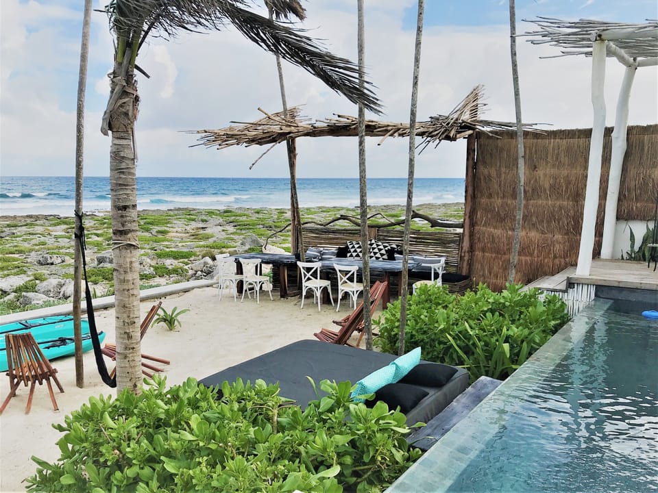 Beach area, table for dinning al fresco and lounge area by the infinity pool