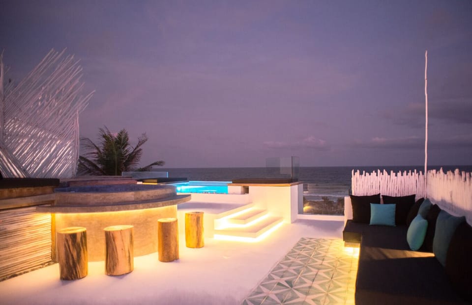 Rooftop at night with jacuzzi, clear bottom pool, and lounge area