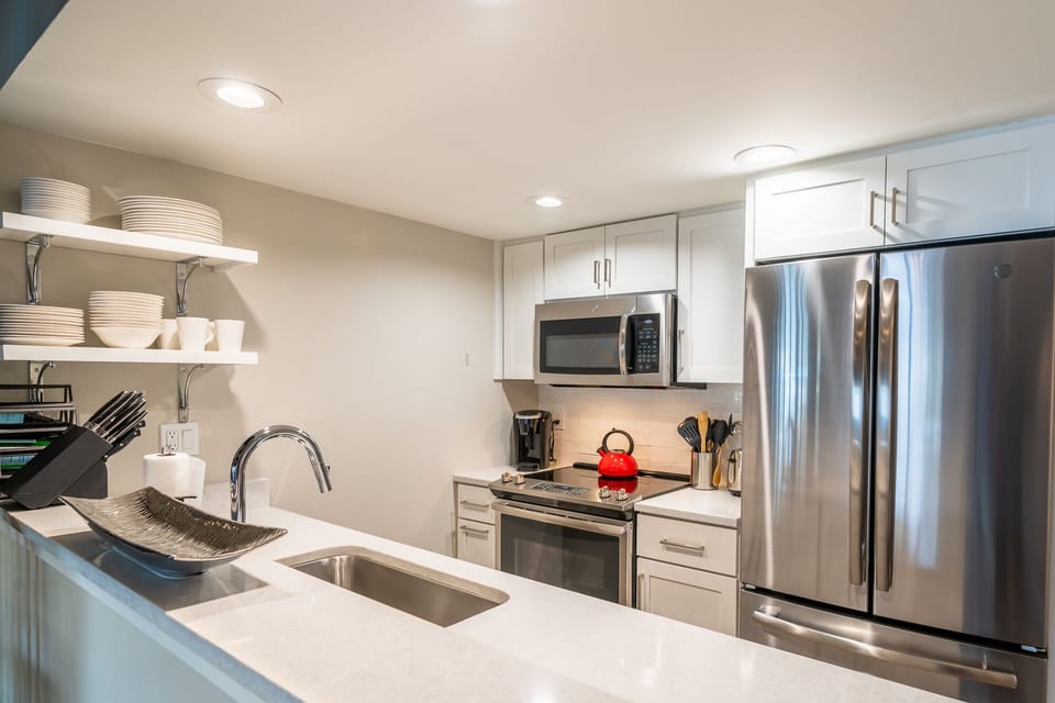 Well appointed kitchen w new appliances, custom cabinetry, quartz countertops 