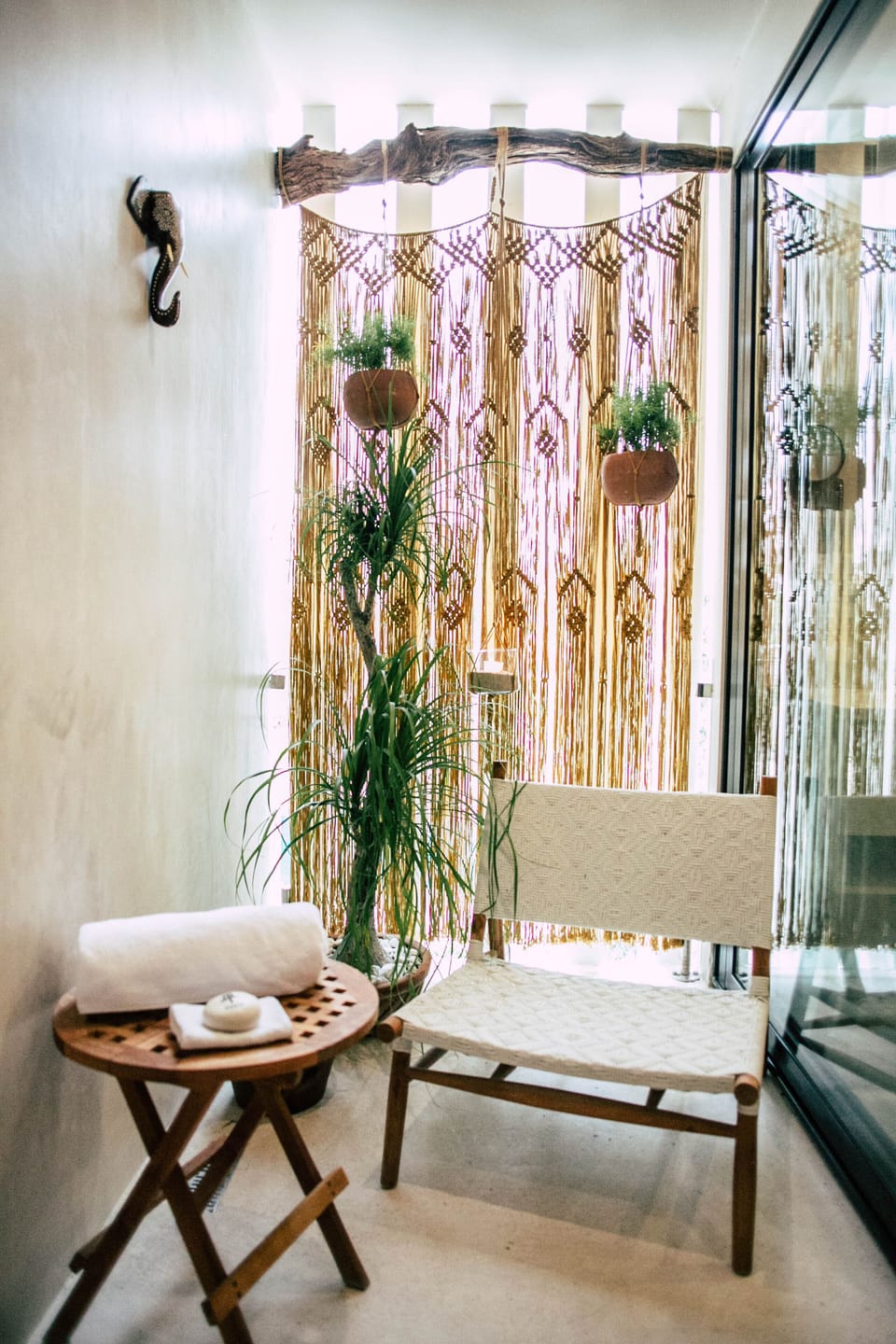 The master bedroom outdoor shower has plants, candles and privacy wall.