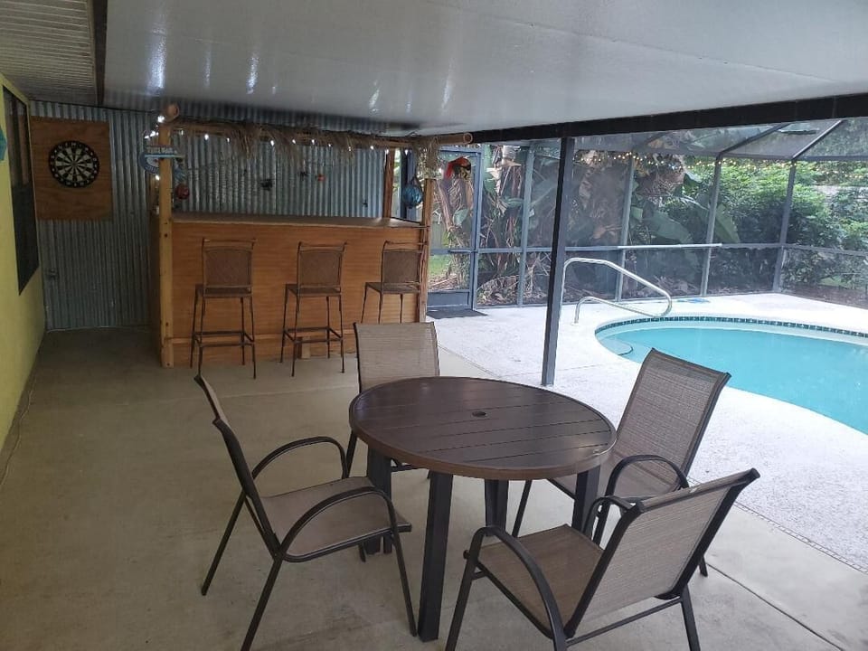 Outdoor dining table seats 4 and tiki bar (seats 3) with dart board for play.