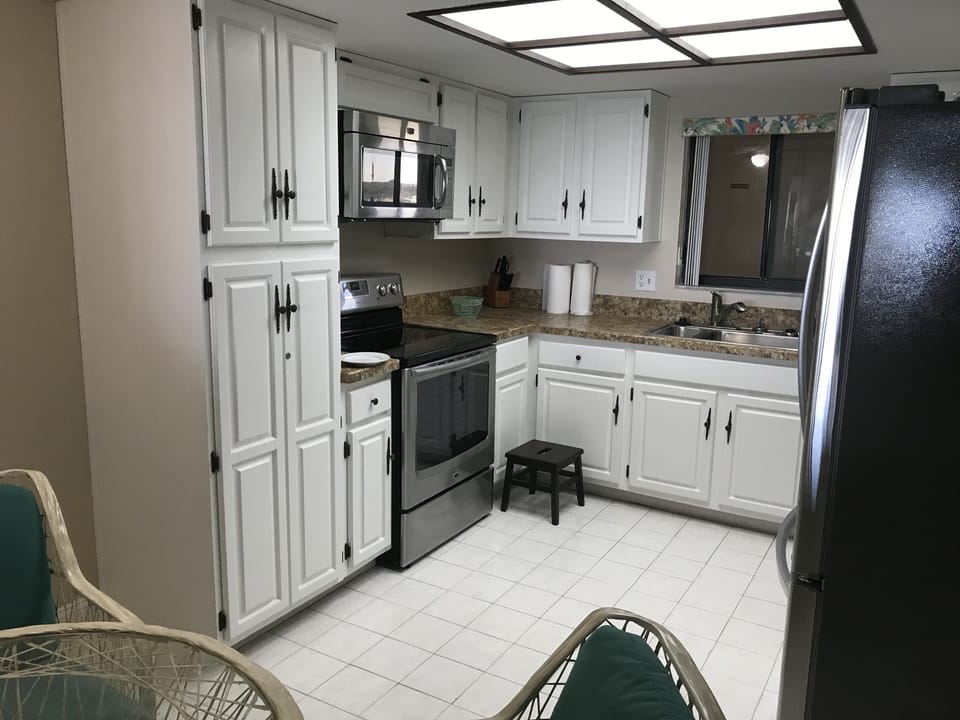 Kitchen with large pantry storage and full set of dishes and pots and pans.