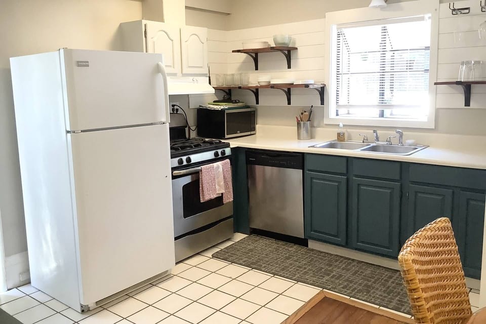 Open shelves, gas stove with plenty of counter space to cook. Entry to the property from the door to the left of the fridge