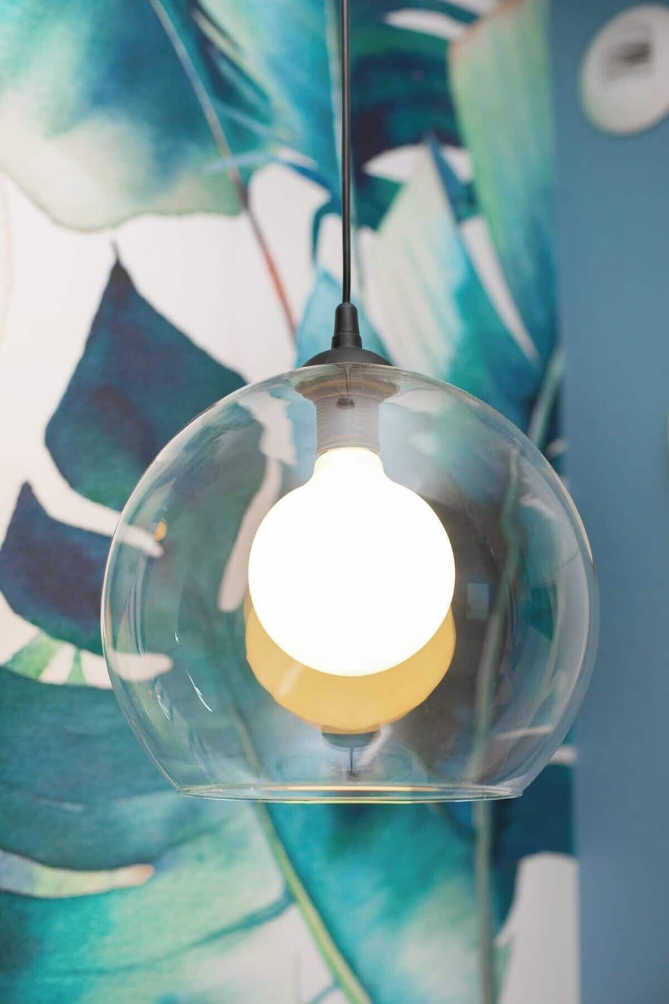 A close-up of tropical-themed wallpaper, adding a bold visual statement to the space.