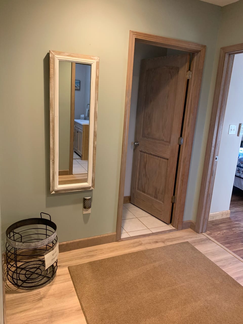 Common area near bathrooms and bedrooms with full length mirror and coat hooks