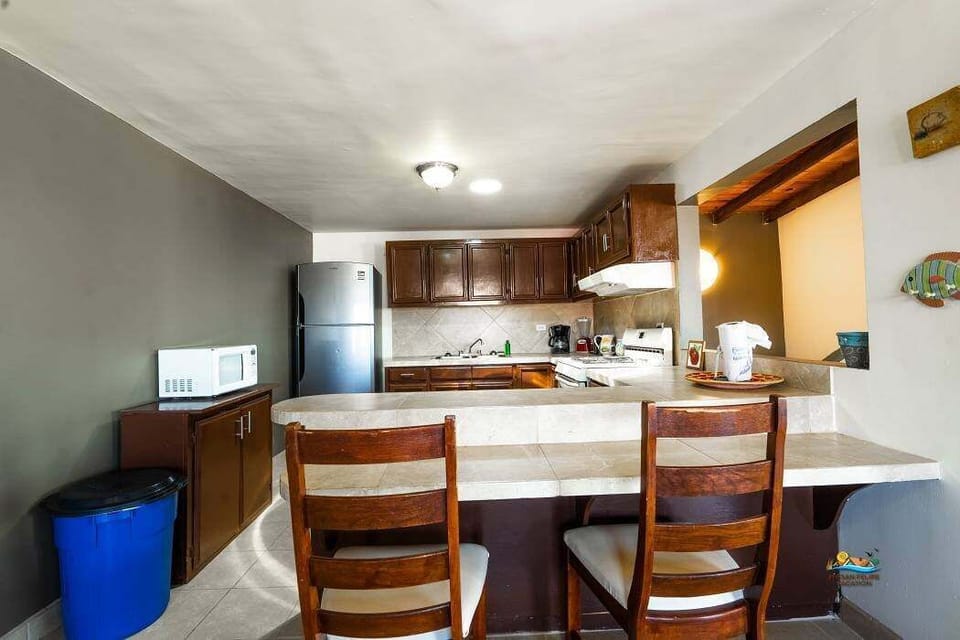 The formal dining area features a large table seating six, set against a window overlooking the beach and Sea of Cortez — a bright, ocean-view space for family meals .