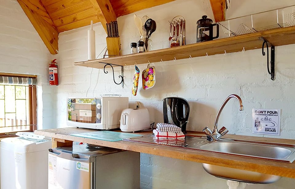 Kitchenette (microwave, toaster, kettle, fridge, washing machine, iron & board).
