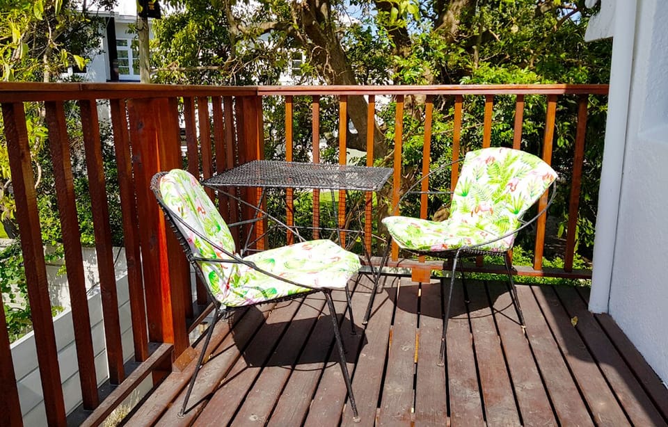 Table & chairs on private north-facing balcony with clear view of Helderberg Mt.