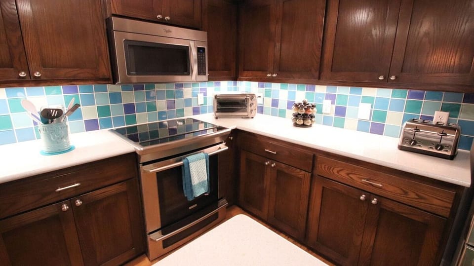  4-burner stove with a warmer, paired with a built-in microwave above. A perfect setup for efficient cooking, blending functionality and style to meet all your culinary needs in this well-equipped kitchen.