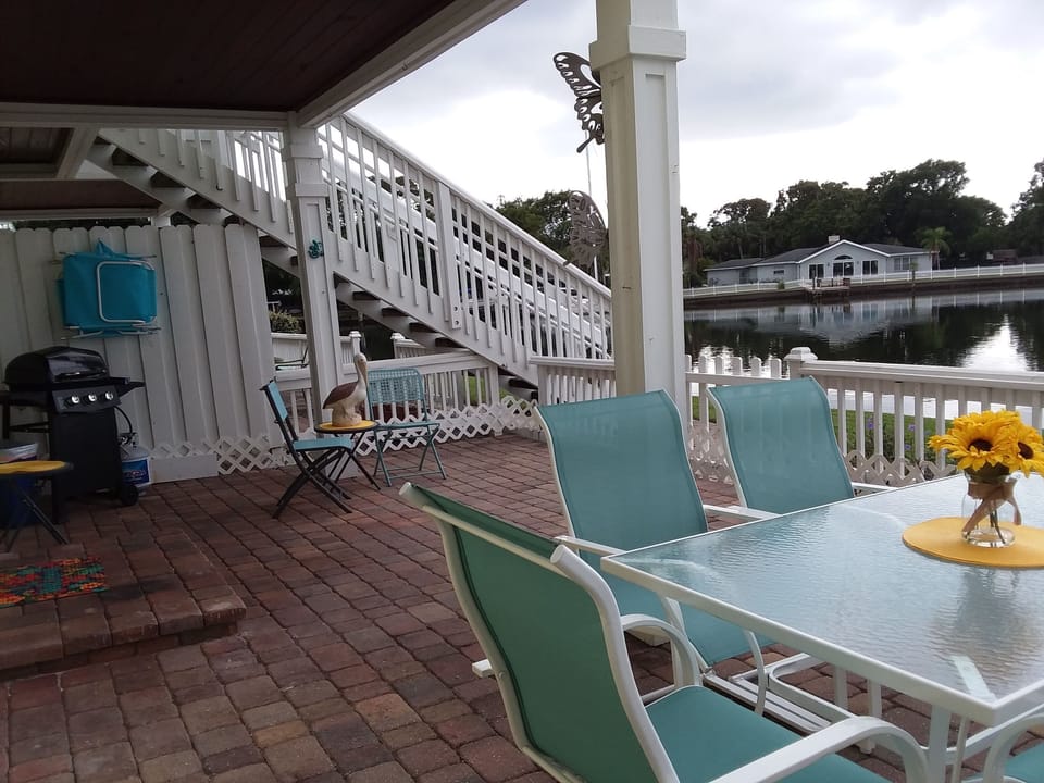 Patio iwith dining table, seating and barbecue, walk through gate to waterfront.