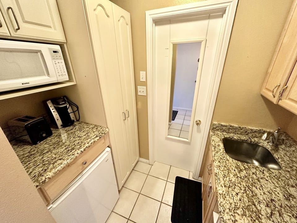Enter the rental unit where you'll find a kitchenette complete with a mini-fridge, coffee maker, hot plate, and microwave.