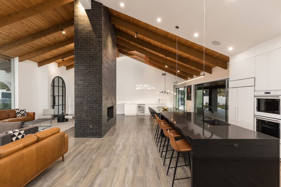 Welcome to a spacious and inviting kitchen, dining, and living room area boasting original wood vaulted ceilings. This expansive layout offers room for gatherings and relaxation, blending rustic charm with modern comfort.
