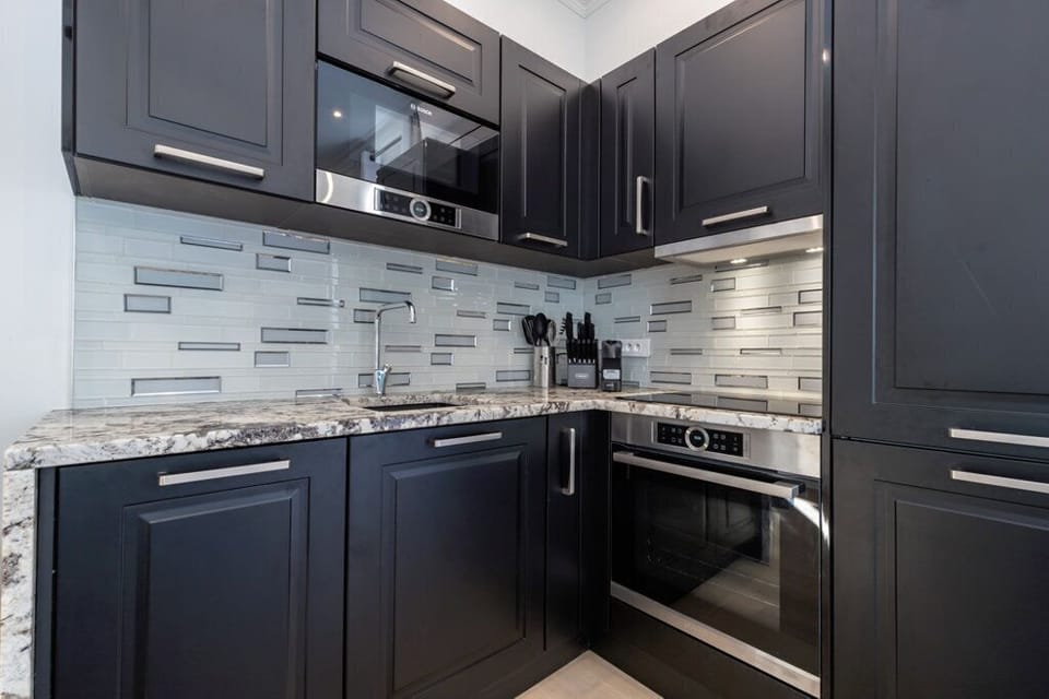THE GOURMET KITCHEN HAS A COOKTOP, OVEN, DISHWASHER, MICROWAVE, AND FRIDGE