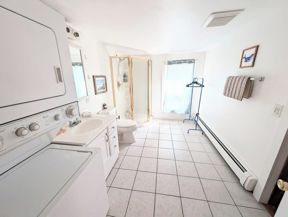 Large bathroom with stand up shower and washer dryer