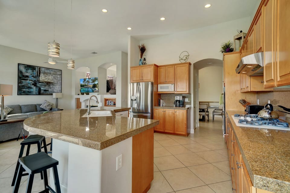 The kitchen is an open concept area which flows to the living, DR and pool room