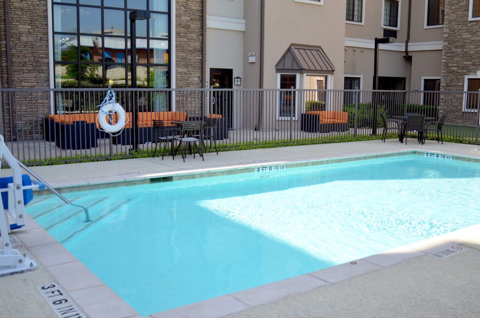 Outdoor swimming pool with bright poolside seating, just moments from SeaWorld San Antonio