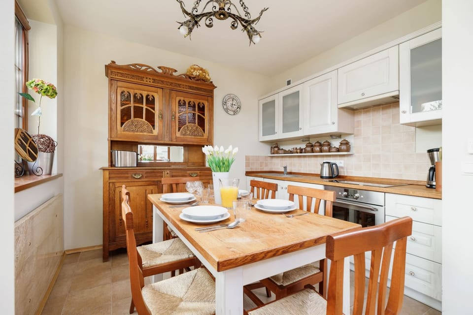 Close-up view of a kitchen with a sink, stove, and white tiled backsplash. Counter space includes modern appliances.