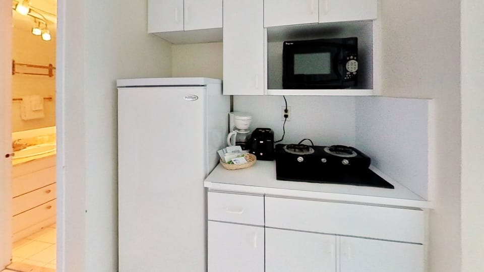Kitchenette equipped with full-size fridge with freezer, double stove, microwave, coffee-maker, toaster, dishes and utensils.
