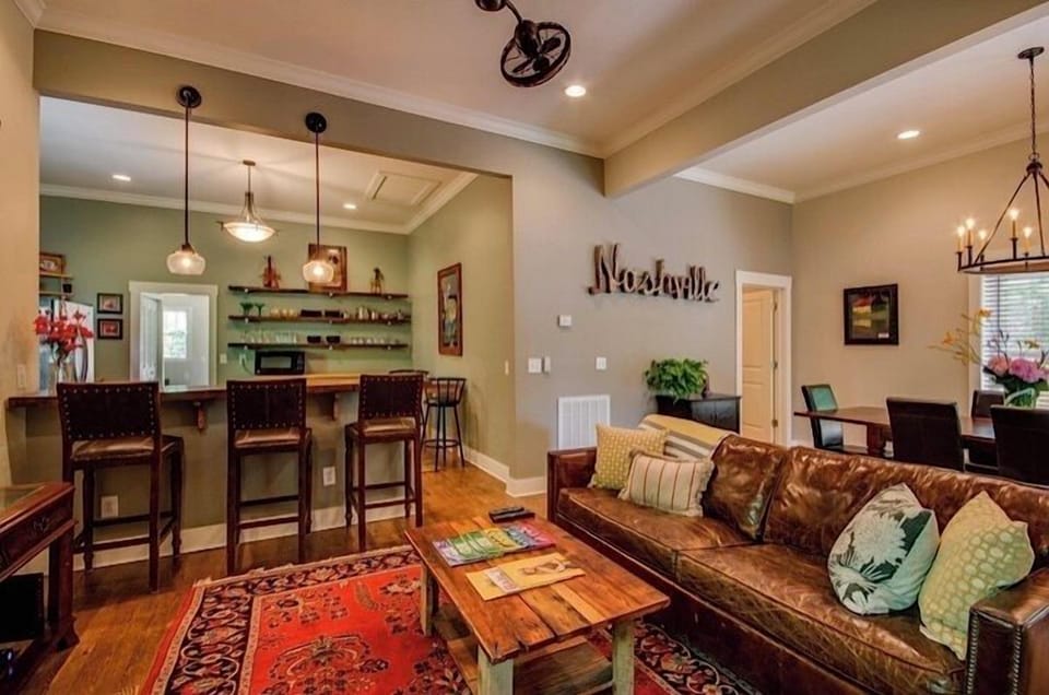 The dining and living room areas are adjacent to the kitchen and its wooden bar.