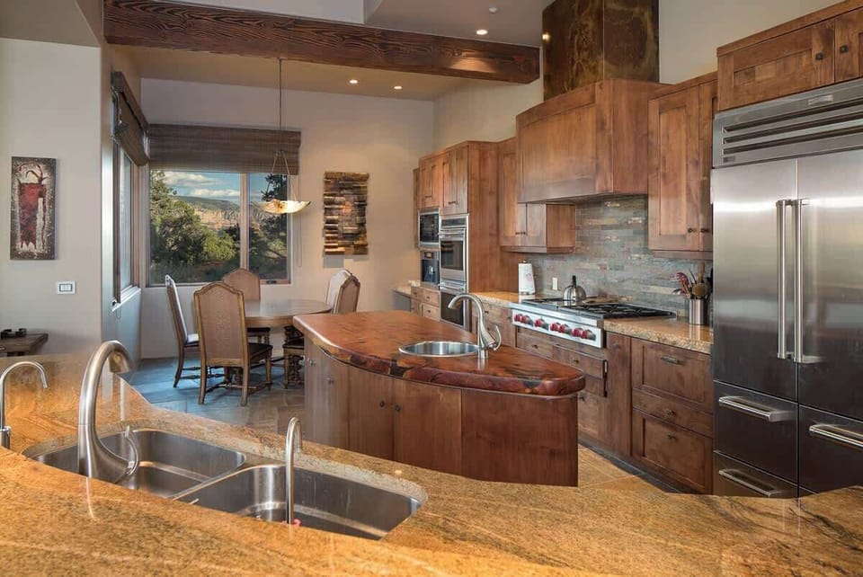 The modern chefs kitchen has Sub Zero, Viking and Dacor appliance with a dining table for 6