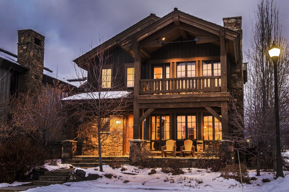 Step into your mountain retreat where warm light spills from every window, welcoming you home after snowy adventures. Relax on your private balcony with a hot cocoa as twilight paints the sky.
