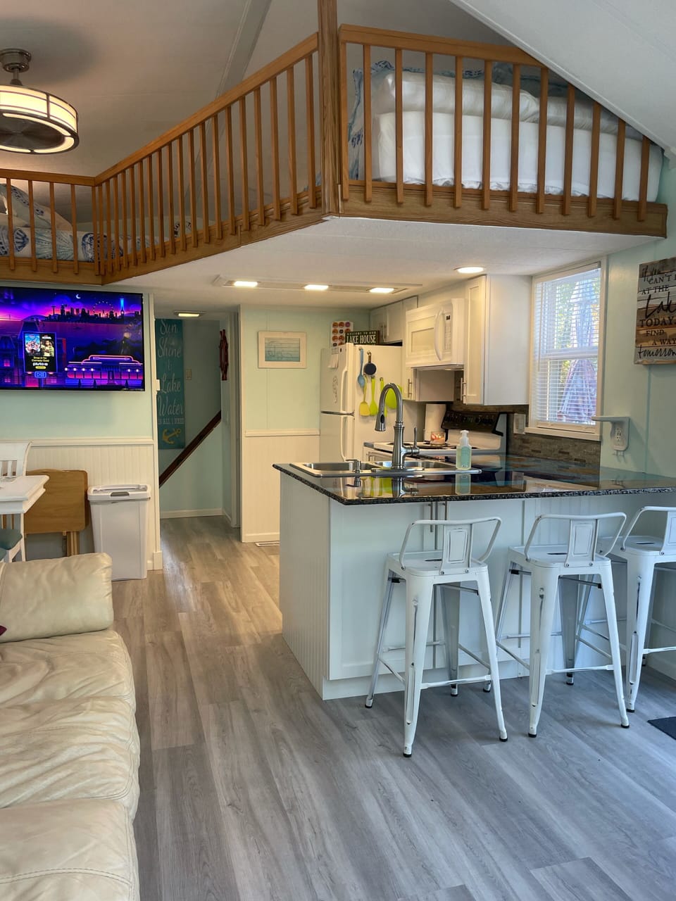 Open kitchen & living room area with upstairs loft with full & queen beds. 