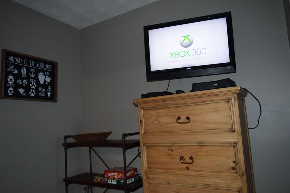 An XBox 360 console, a controller, a blu-ray player and some games and movies.