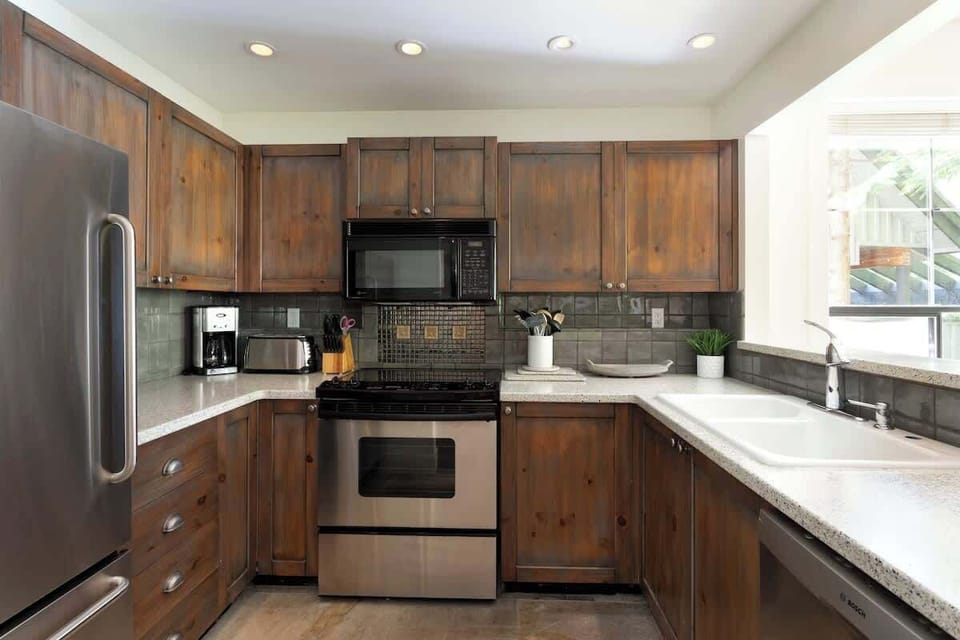 - Fully equipped kitchen with stainless steel appliances and wood cabinets  
- Bright window lighting perfect for morning coffee moments  
- Cook favorite meals after skiing or exploring Whistler village  
