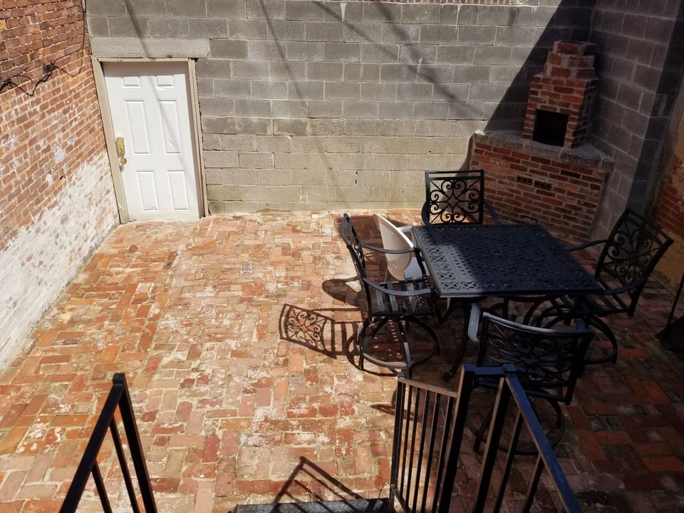 Rear patio with table/chairs and brick grill