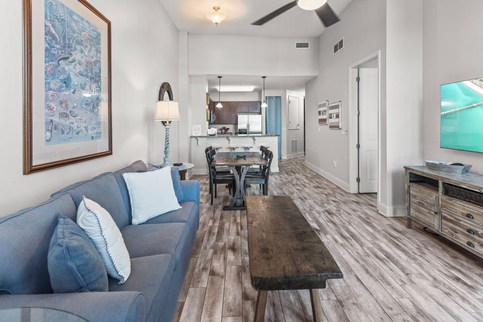 Relax in your bright, open living space featuring coastal blues and comfortable seating that flows seamlessly into the dining area.