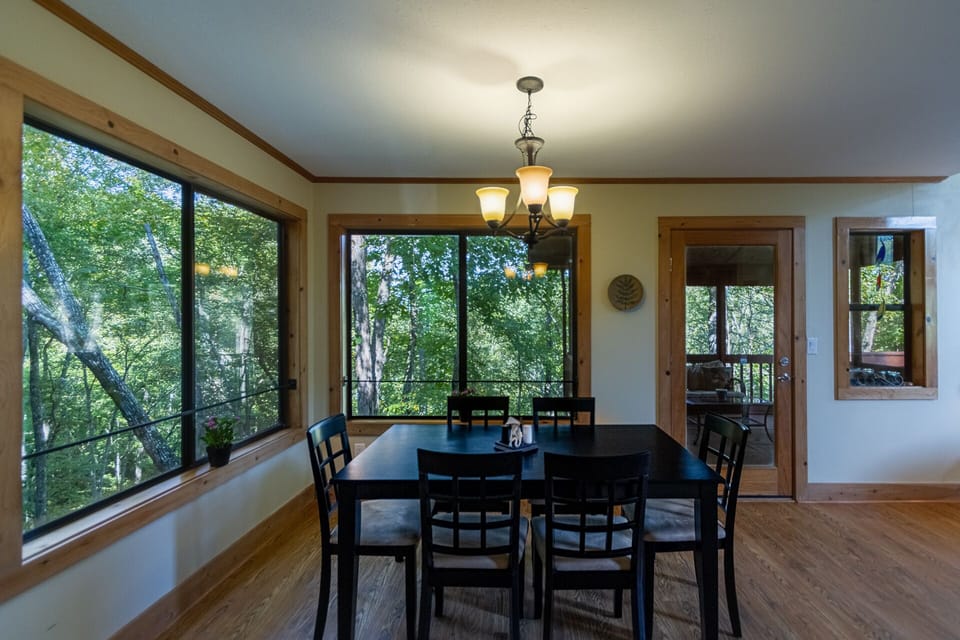 Bright dining area with forest view and seating for 6