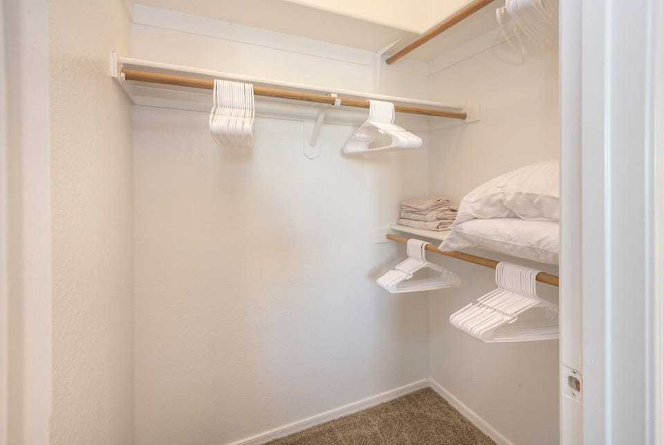 Guest Walk-in closet with hangers and extra pillows